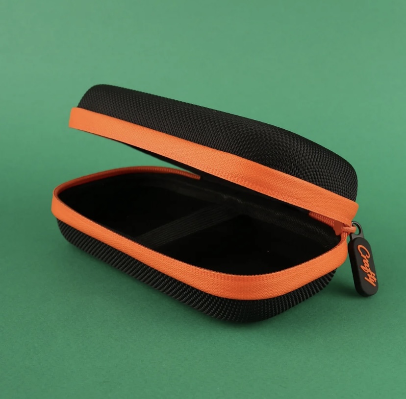 Hard-shell Black Case with an Orange Zipper Opened to Reveal an Empty Interior Against a Green Background - Australia E-cigarette Store