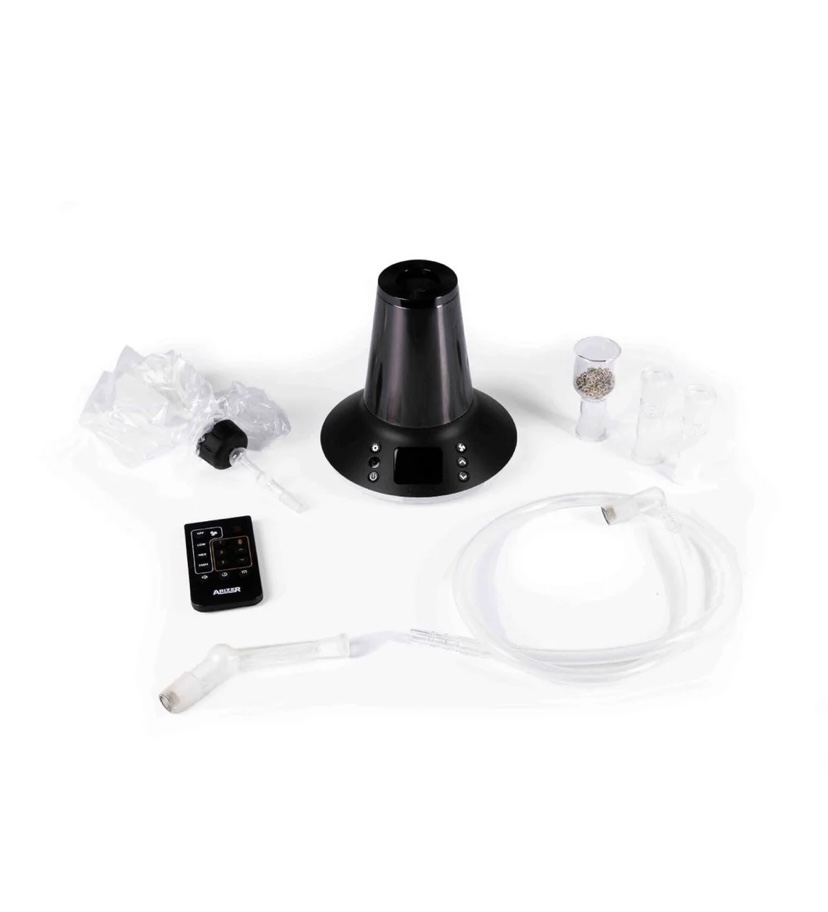 Home nebulizer kit on a white surface: black base unit with display, clear tubing, mouthpiece, and assorted accessories.