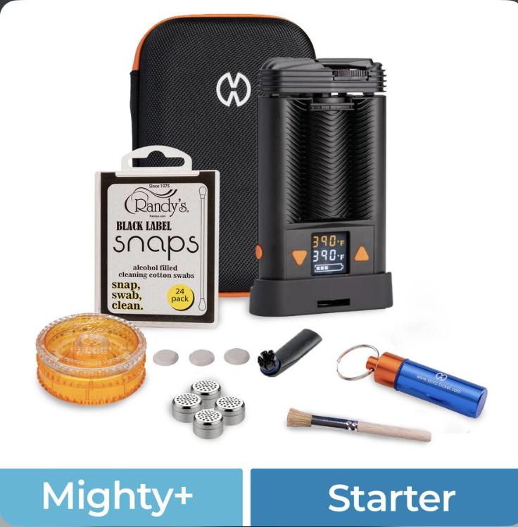 Mighty+ Starter portable vaporizer kit with black device, orange-trim case, and assorted cleaning tools and accessories laid out.