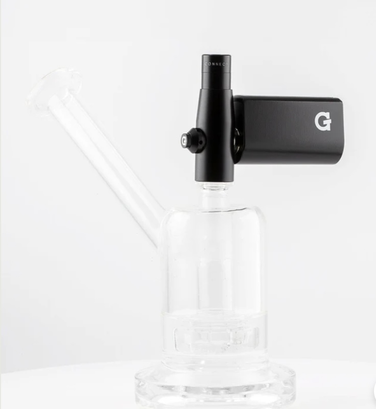 Clear glass dab rig with a black electronic attachment mounted on top, used for concentrating vapors.