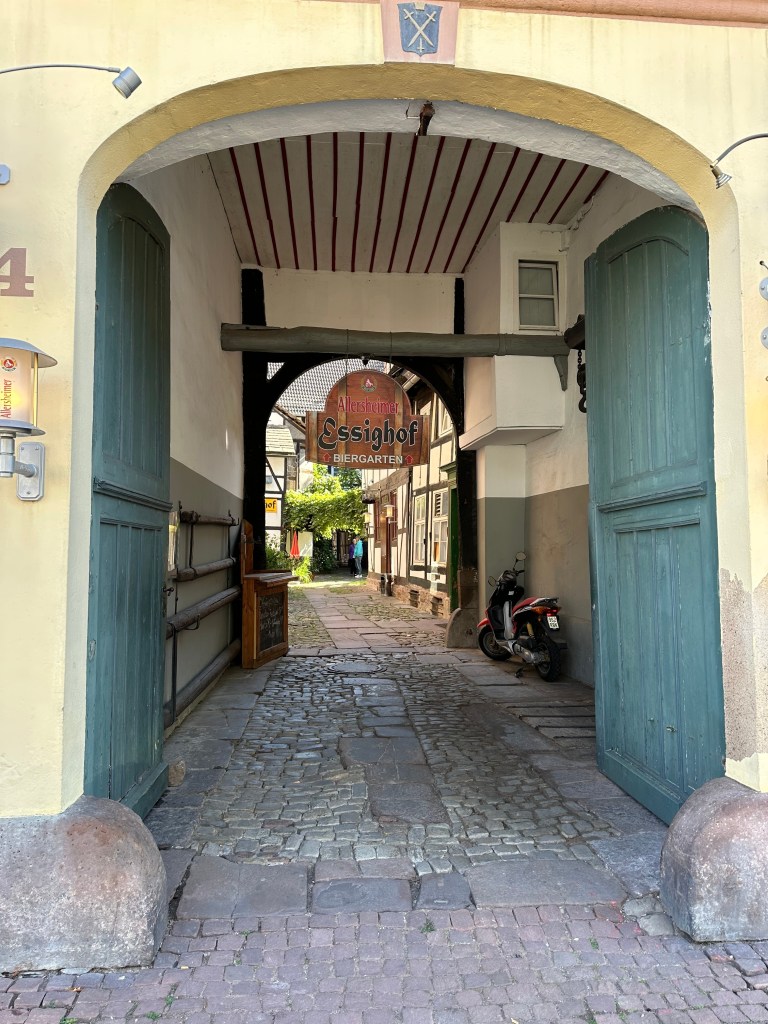 Eingang zum Essighof Biergarten in Holzminden durch ein historisches Tor mit Blick in den Innenhof