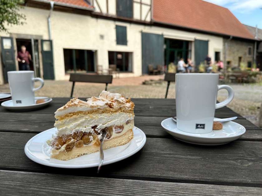 Stachelbeertorte mit Schlagsahne und Tasse Kakao im Hofcafé Flegessen