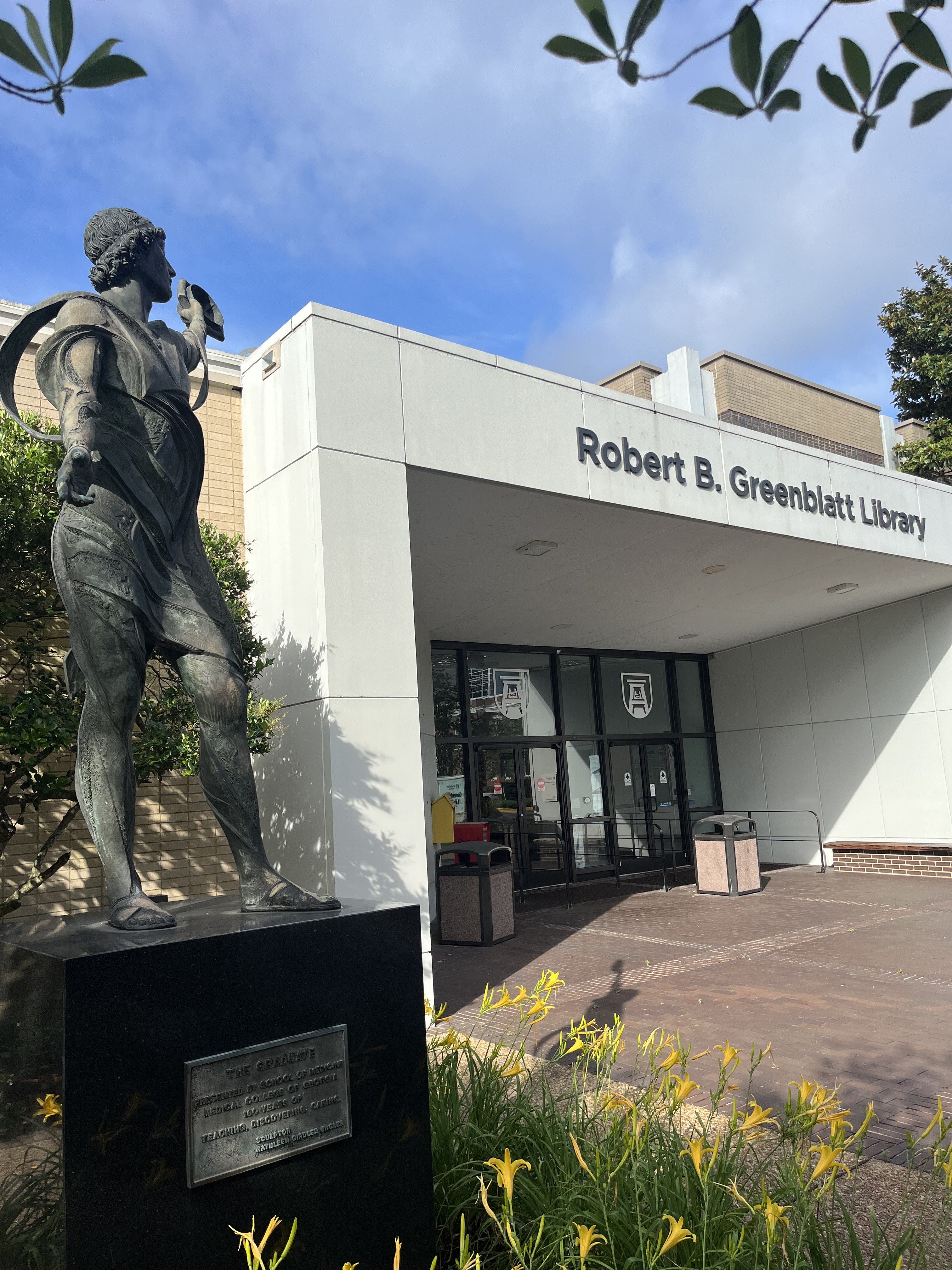 Entrance of Greenblatt Library with The Graduate statue