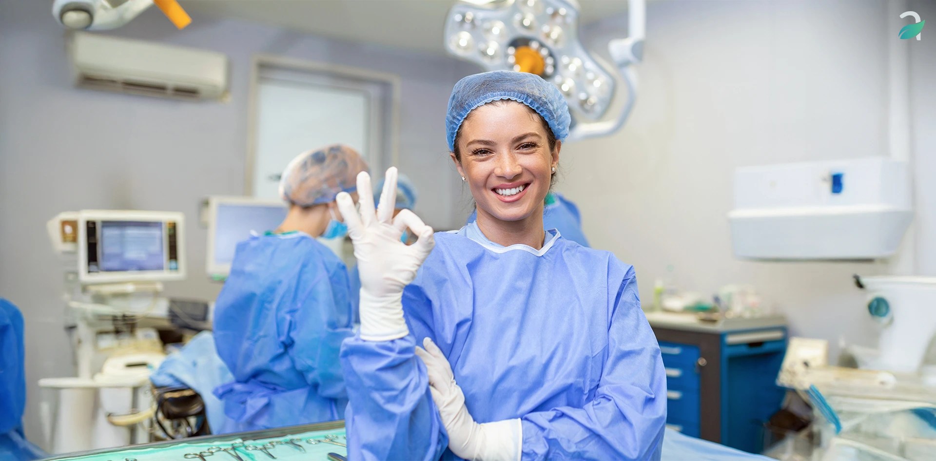 Smiling healthcare professional in a surgical room showing OK hand sign, symbolizing clean and safe environment