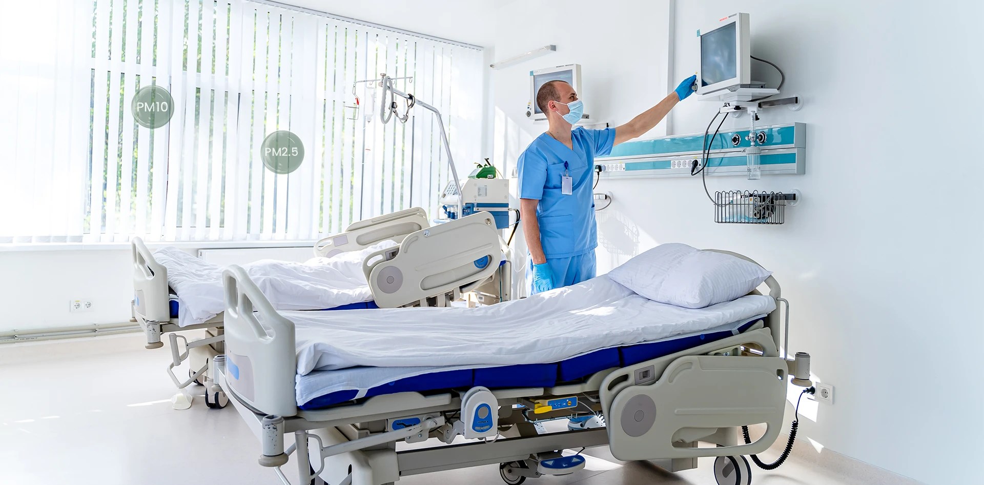 Nurse adjusting equipment in a hospital ward with two patient beds, illustrating how Real Time Air Quality Data is Transforming Healthcare by tracking PM2.5 and PM10 levels for safer clinical environments.