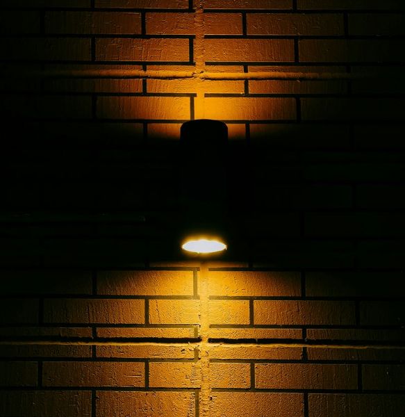 A wall-mounted light fixture casting warm illumination onto the wall.