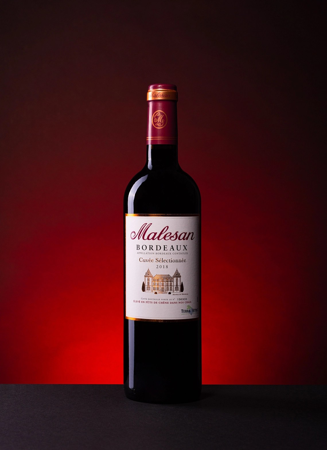 Photographie d'une bouteille de vin rouge bordeaux sur fond noir et halo rouge - Photographe publicitaire boissons - photographe bouteille de vin - photographe commercial - Aurore Aivrest