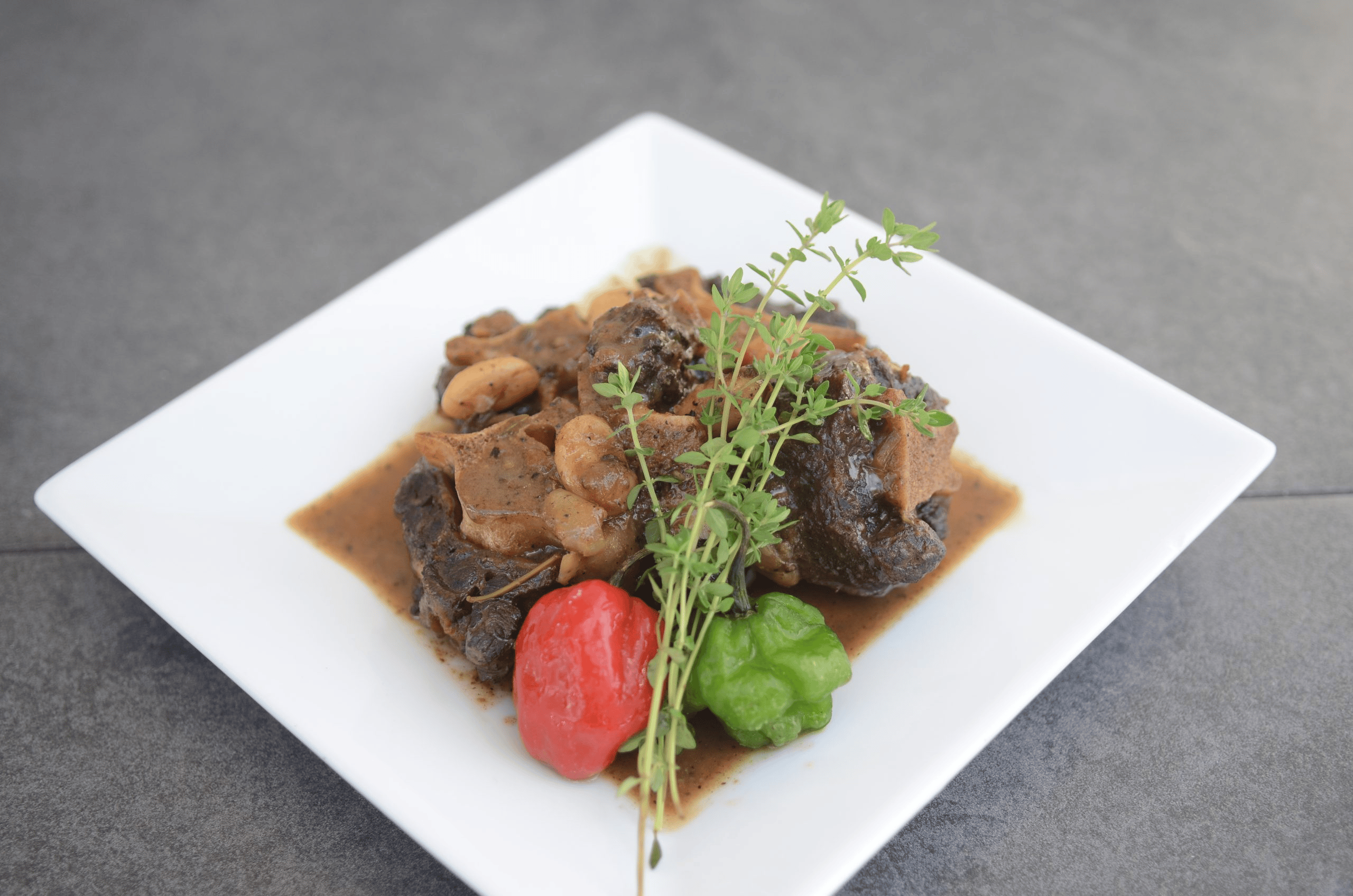 Jamaican oxtail with gravy, herbs and Scotch bonnet peppers prepared by Chef Nadine.