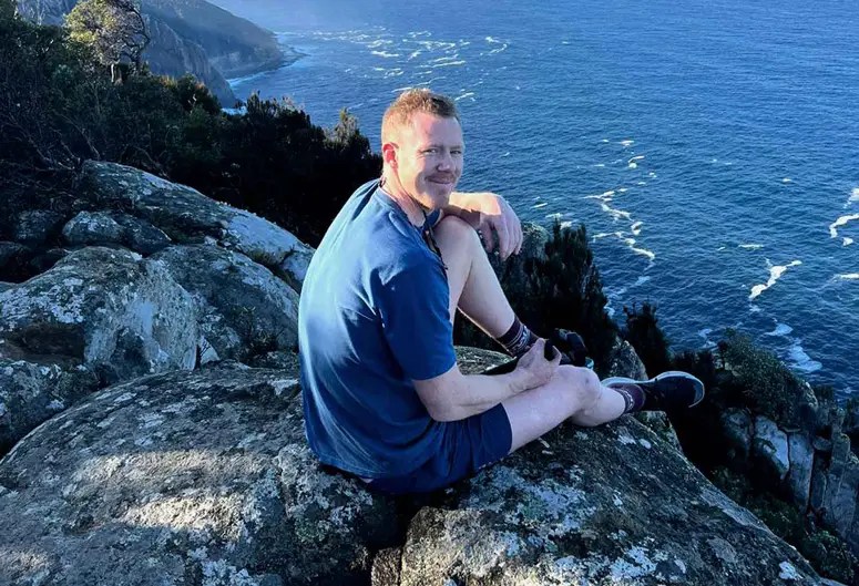 Blog Post Cover: Jack Riewoldt sitting on the cliff edge in Three Capes, Tasmania