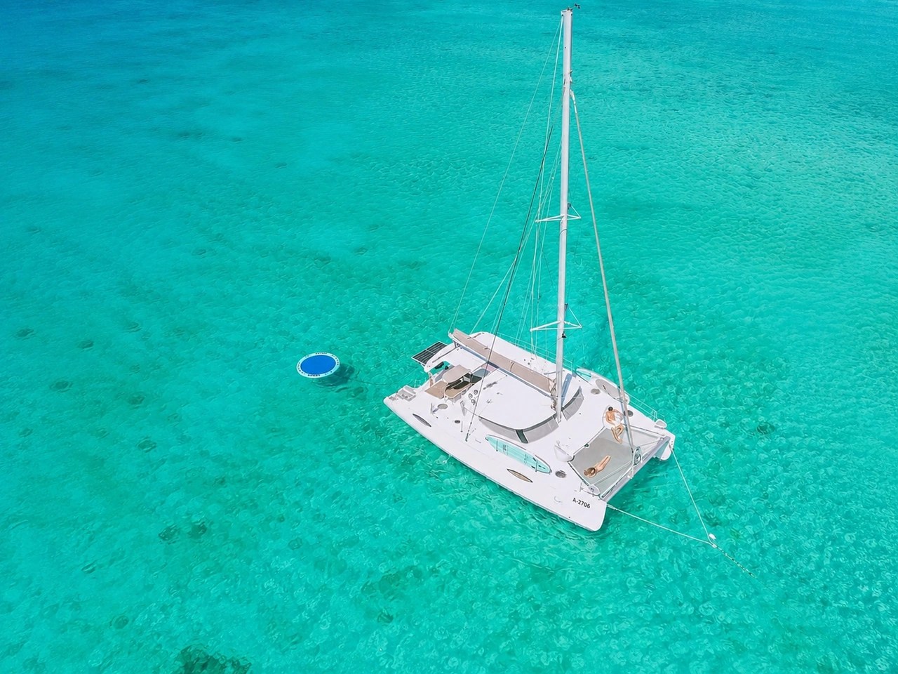 Aerial view of AWA, a 44ft Fountaine Pajot Orana catamaran, anchored on clear turquoise water in Aruba