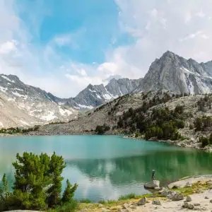 hiker in front of alpine lake in bishop ca