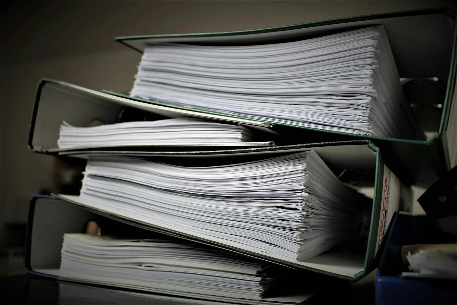 Close-up of stacked binders filled with documents for office or educational use.