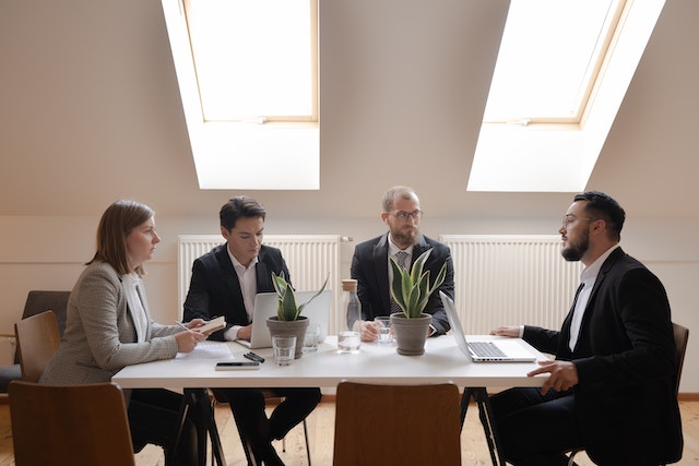 Four individuals engaged in a focused negotiation at a table.