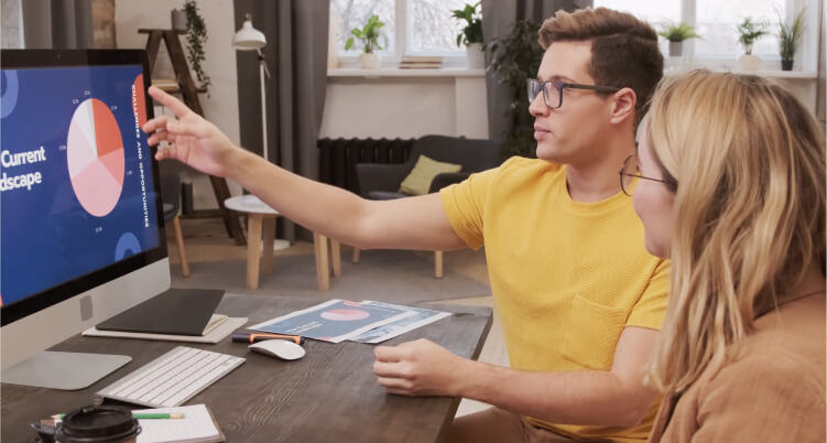 Person explaining digital marketing concepts using a pie chart on a computer screen, illustrating the current landscape of digital marketing strategies in a modern workspace.