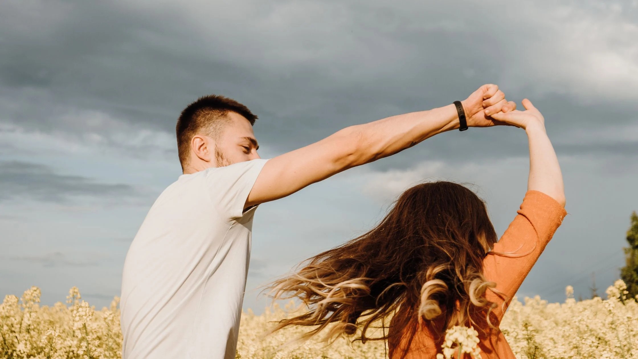 Couple dancing, man holding his hand over a woman to turn her in dance