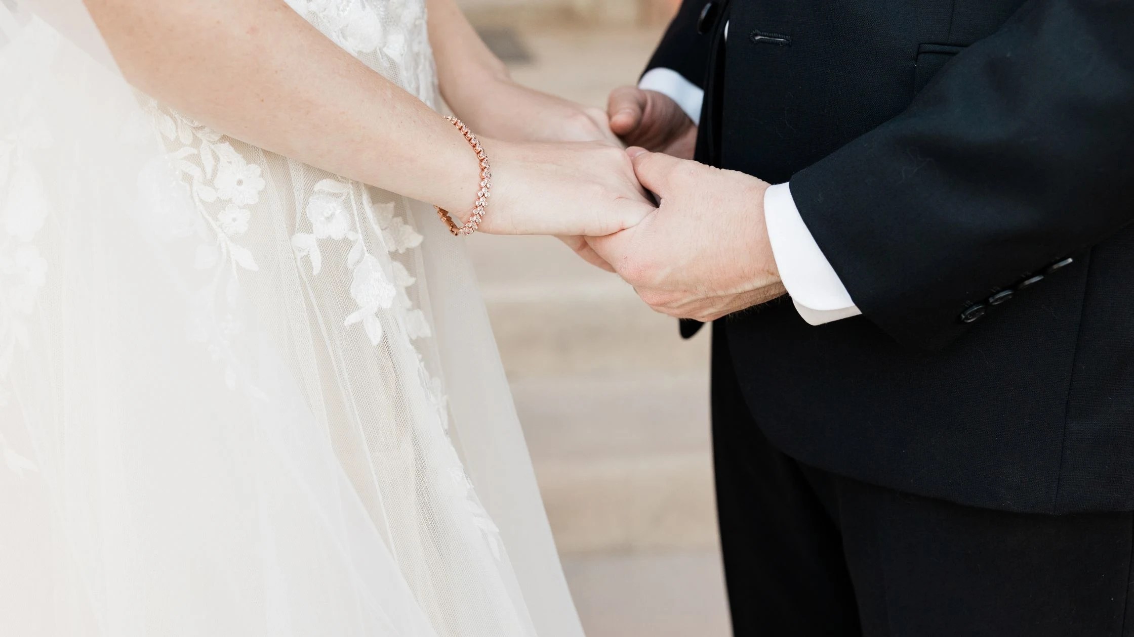 groom holding his bride's hands during wedding ceremony