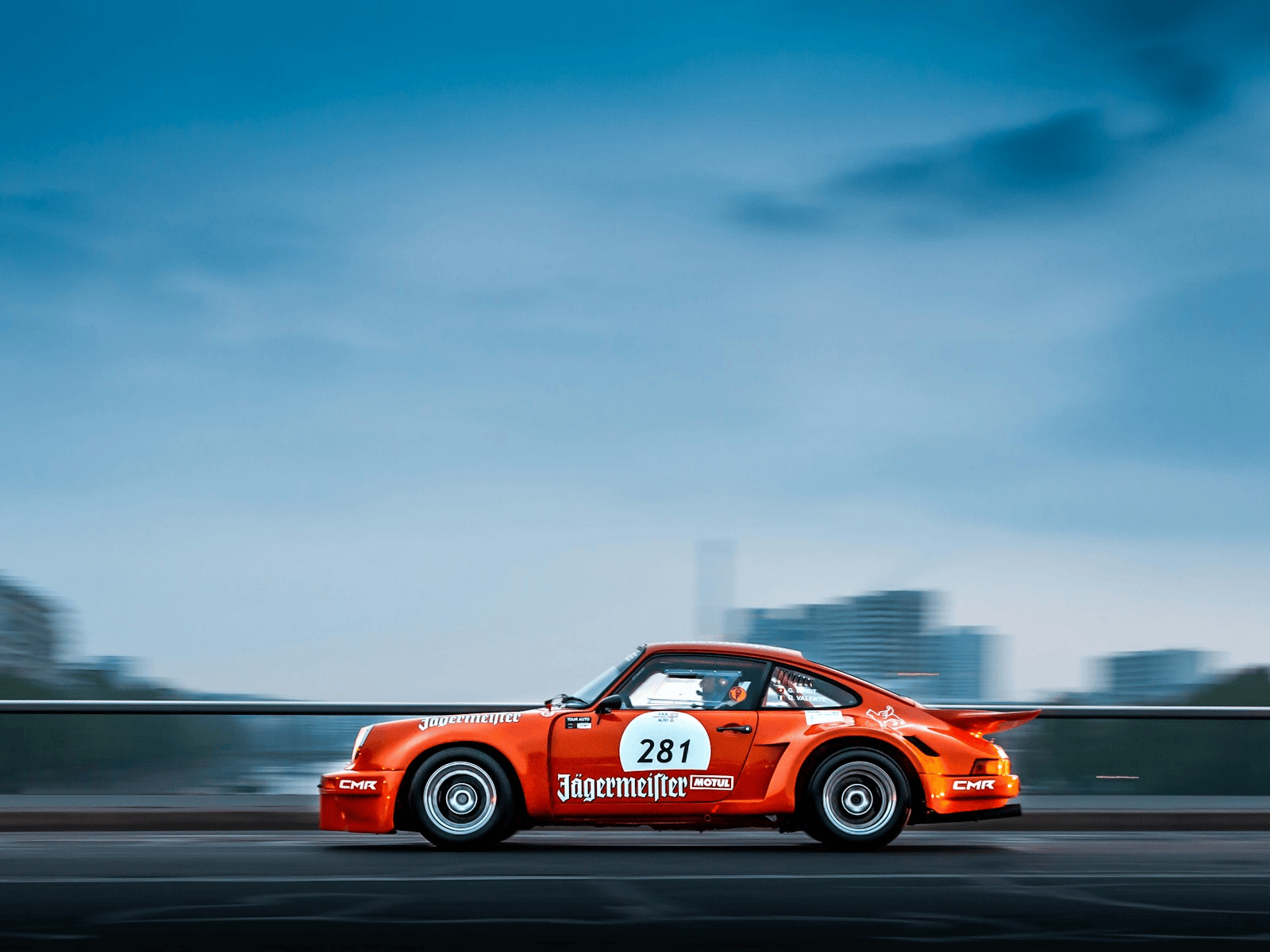 Vintage liveried Porsche 911 racing on a road course, similar to the classic cars competing in HSR's Classic 10 Hour at Road Atlanta