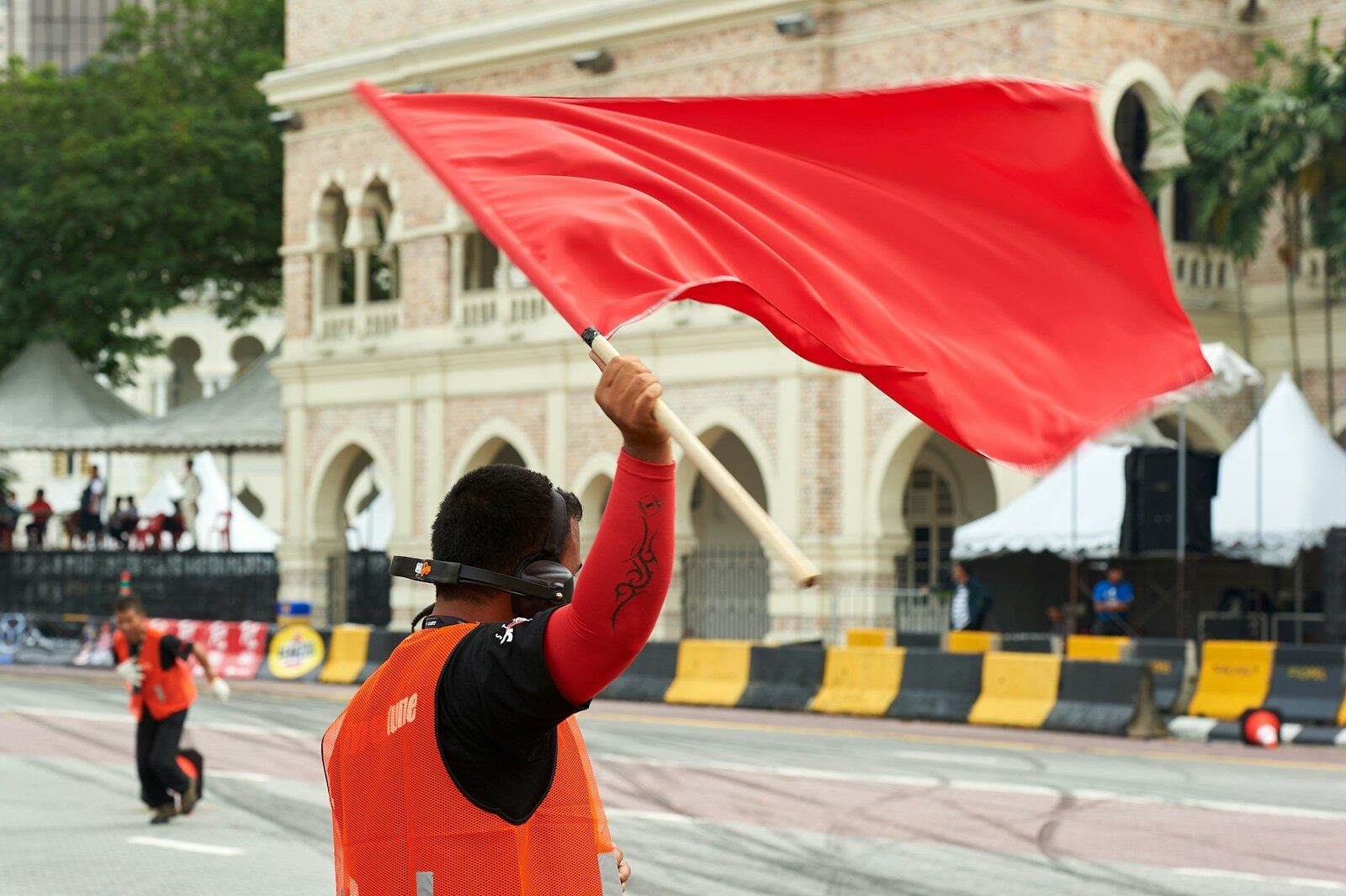A person waves a red flag at a race