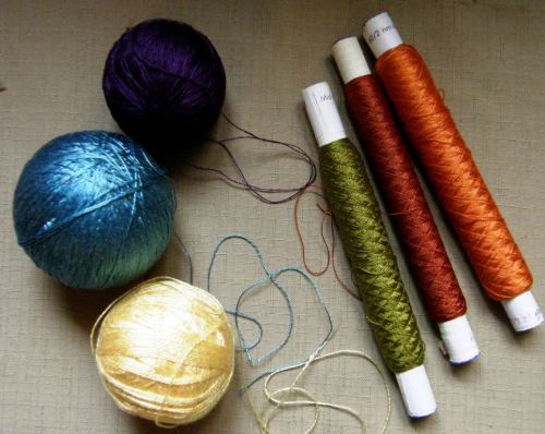 Light blue Japanese silk, spools of 60/2 silk, yellow 8/2 tencel and purple Guatemalan cotton.