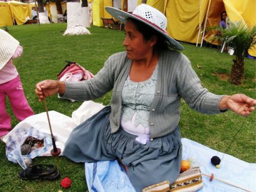 Maxima in Cochabamba adds extra twist to her hanspun yarn before winding a warp for a pebble weave band.