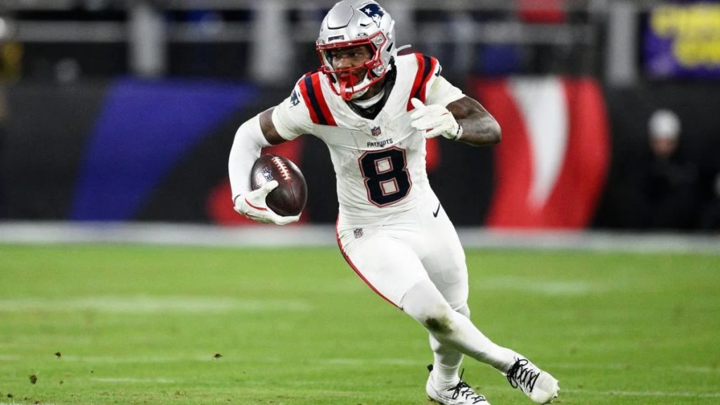 New England Patriots wide receiver Stefon Diggs (number 8) running down the field with a football during an NFL game.