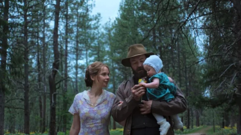 Robert Grainier and Gladys Olding walking through a forest with their baby daughter.