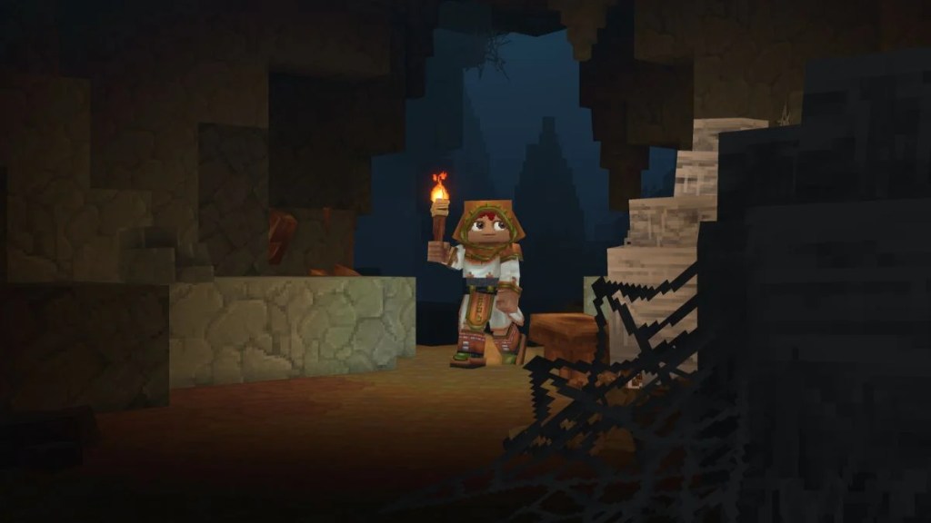 A Hytale character holding a torch while exploring a dark, web-filled underground cave system where late-game ores like Mithril are expected to spawn.