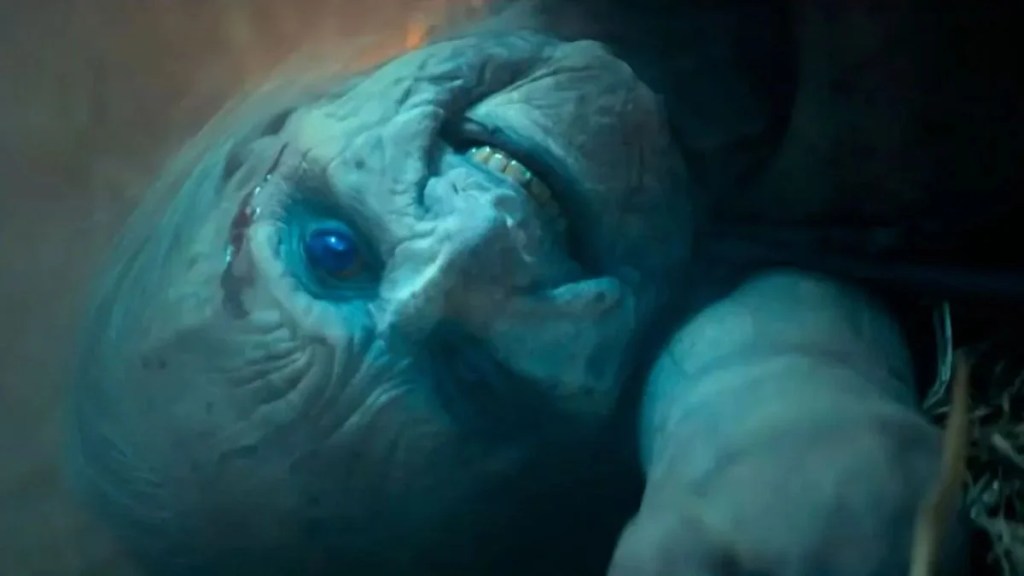 A close-up view of a terrifying, withered, and pale elderly corpse lying on the ground in Whistle.