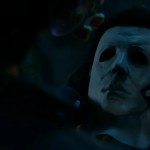 Close-up of Michael Myers putting on his iconic white mask in Halloween: The Game.