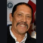 Danny Trejo smiling while posing at a public event.