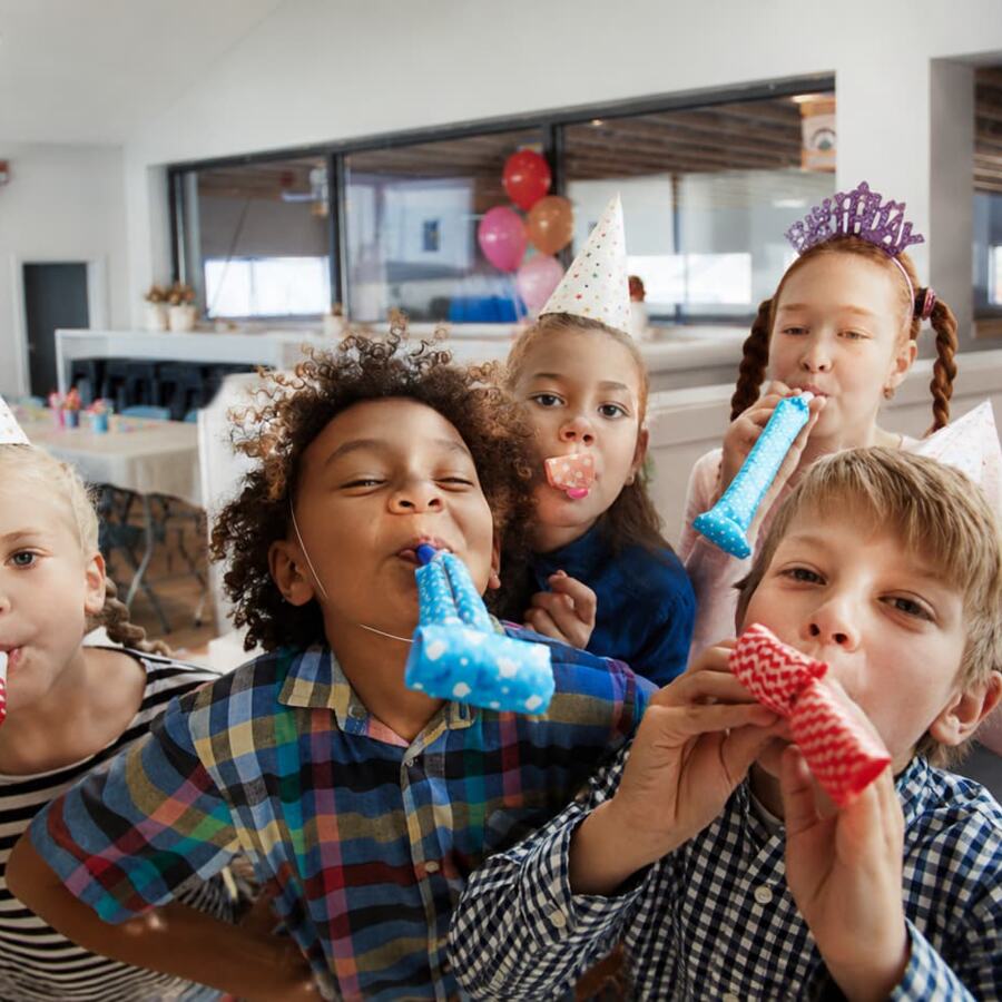 Kids blowing party horns celebrating a birthday party at COGA