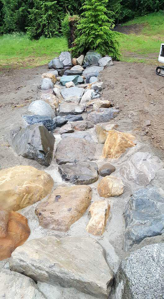 Large rocks in place, bedded in concrete.