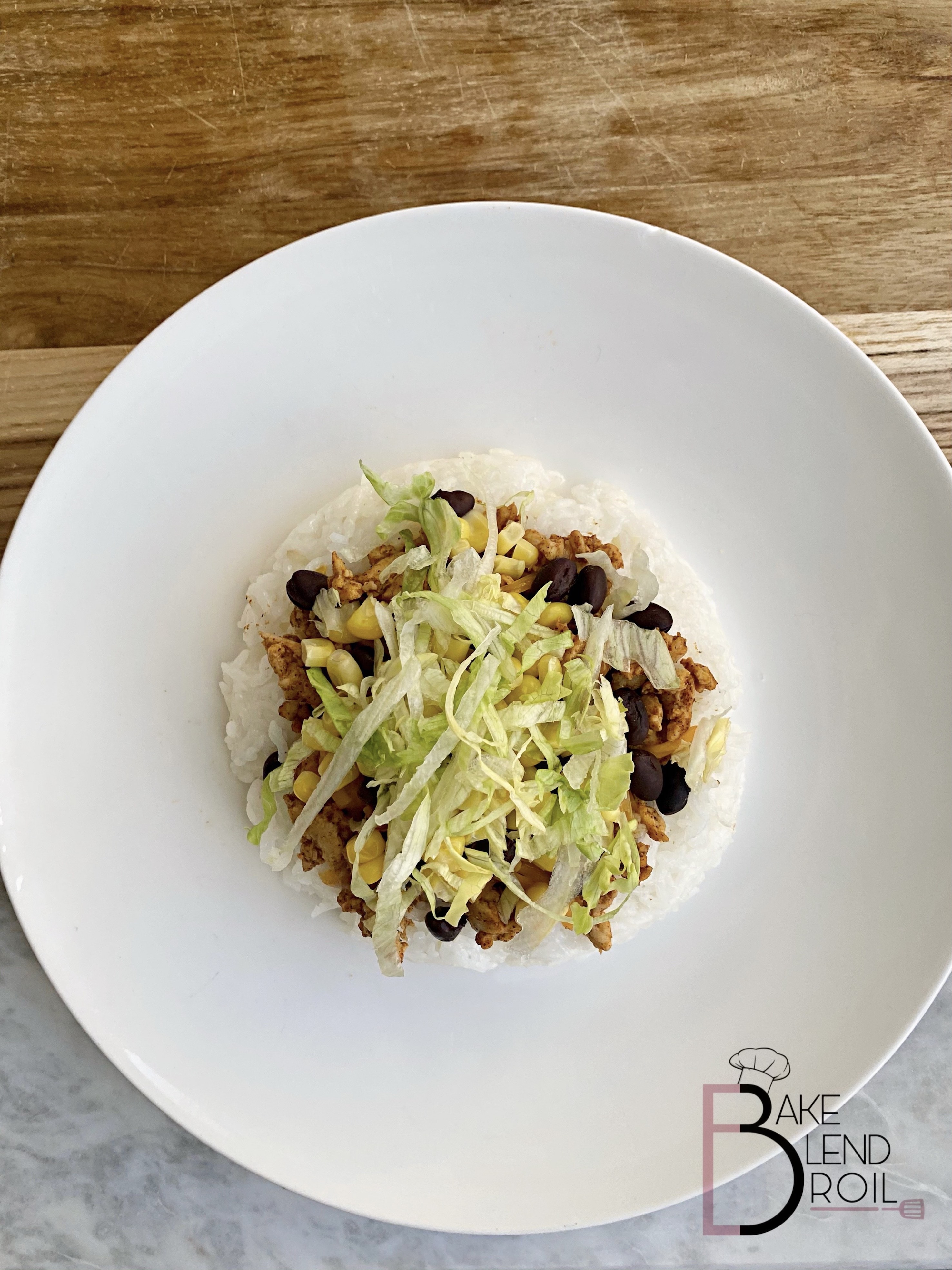 Ground Turkey, black beans, corn, lettuce, tomatoes, and taco seasoning served over a bed of rice.