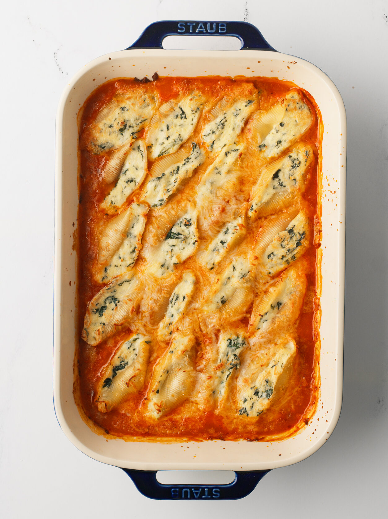 Stuffed Shells in a baking dish with melted cheese.
