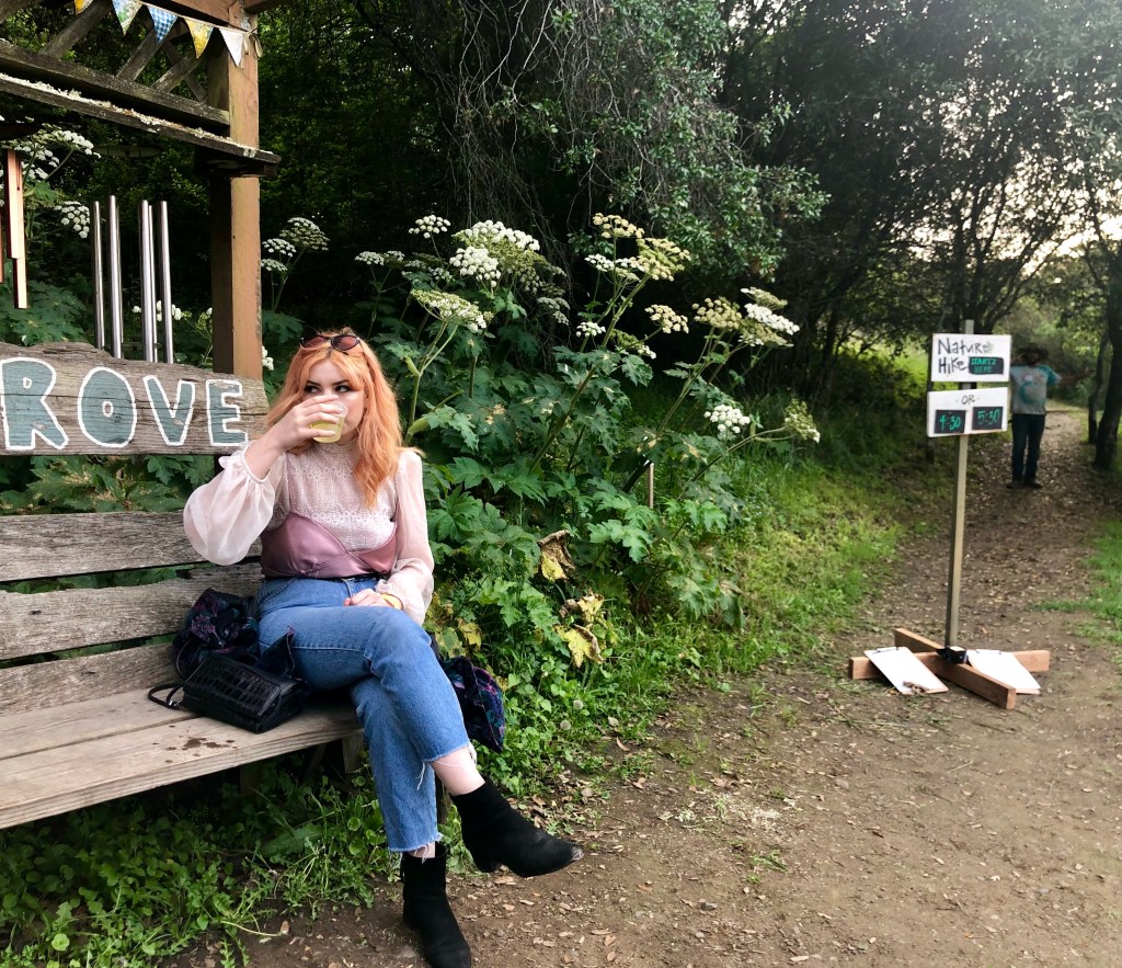 Madison tasting some cider at the entrance to "The Grove"
