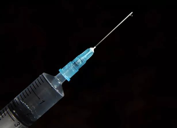 Close-up of a medical syringe on a dark background, representing Ballee Pharmacy’s occupational health vaccination service for employees, contractors, and workplace safety compliance.