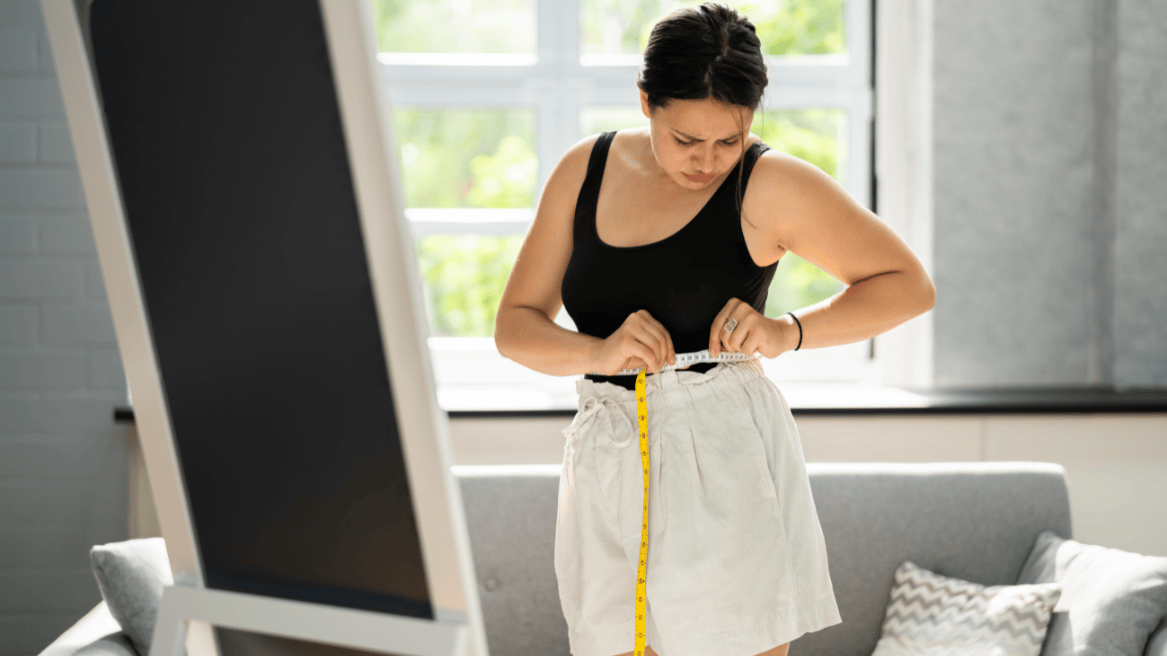 Woman measuring her waist at home, symbolising Ballee Pharmacy’s pharmacist-led weight management service offering tailored plans and treatment support for healthy weight loss.