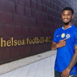 Jorrel Hato poses in Chelsea shirt after completing transfer from Ajax