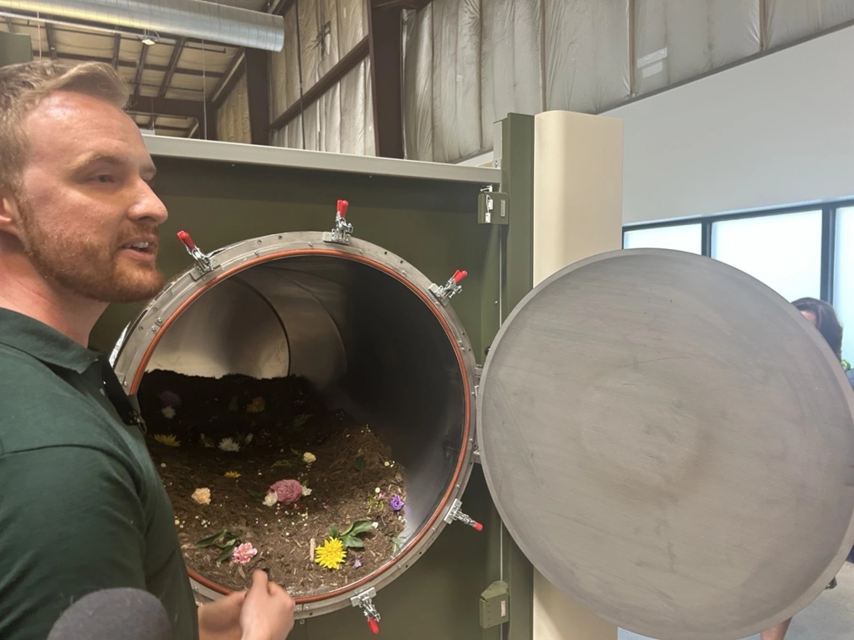 Earth Funeral CEO Tom Harries stands by one of the vessels used to compost human bodies after death. The tubes hold mulch, fungi and bacteria that help turn bodies into soil. Photo credit: Scott Maucione/WYPR News.