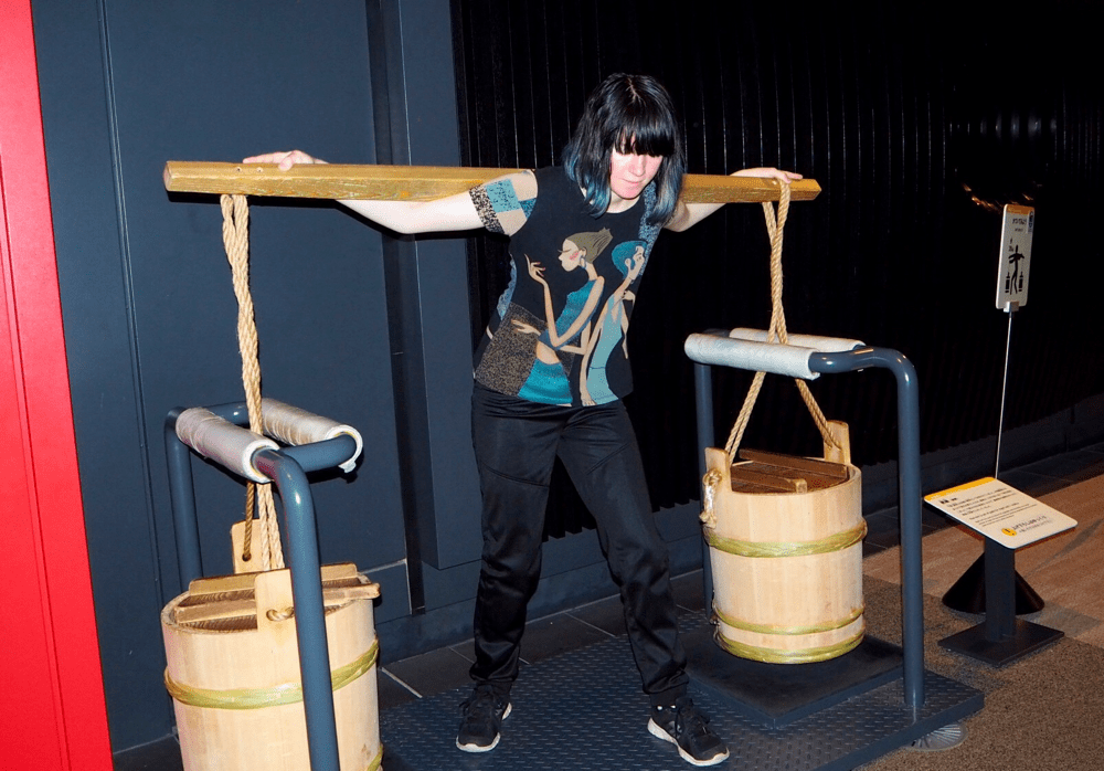 Kaisa prøver å bære vannbøtter.