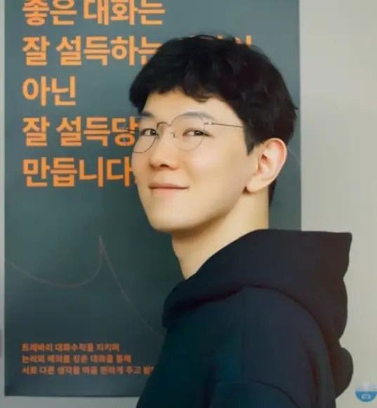 포스터 앞에서 미소 짓는 트레바리 대표