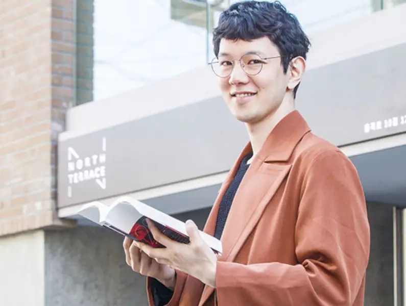 트레바리 대표가 독서 공간 앞에서 책을 읽는 모습