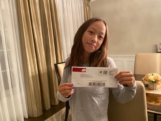 CAMPer opening up their welcoming envelope pre-CAMP 2021!