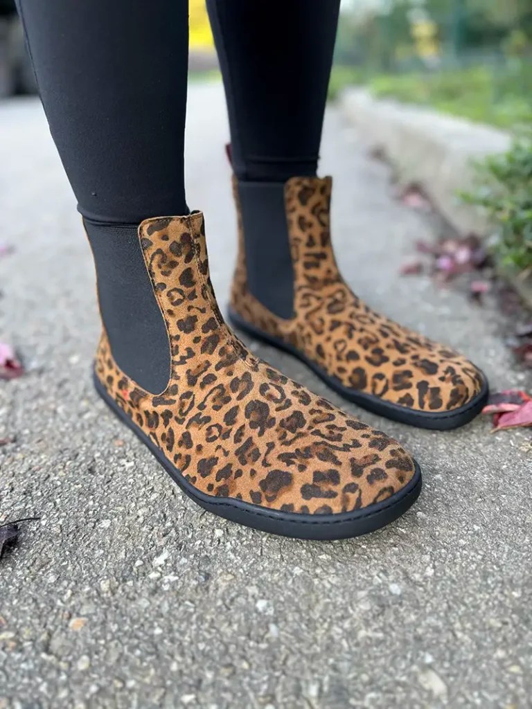 Leopard-print barefoot Chelsea boots paired with black leggings.
