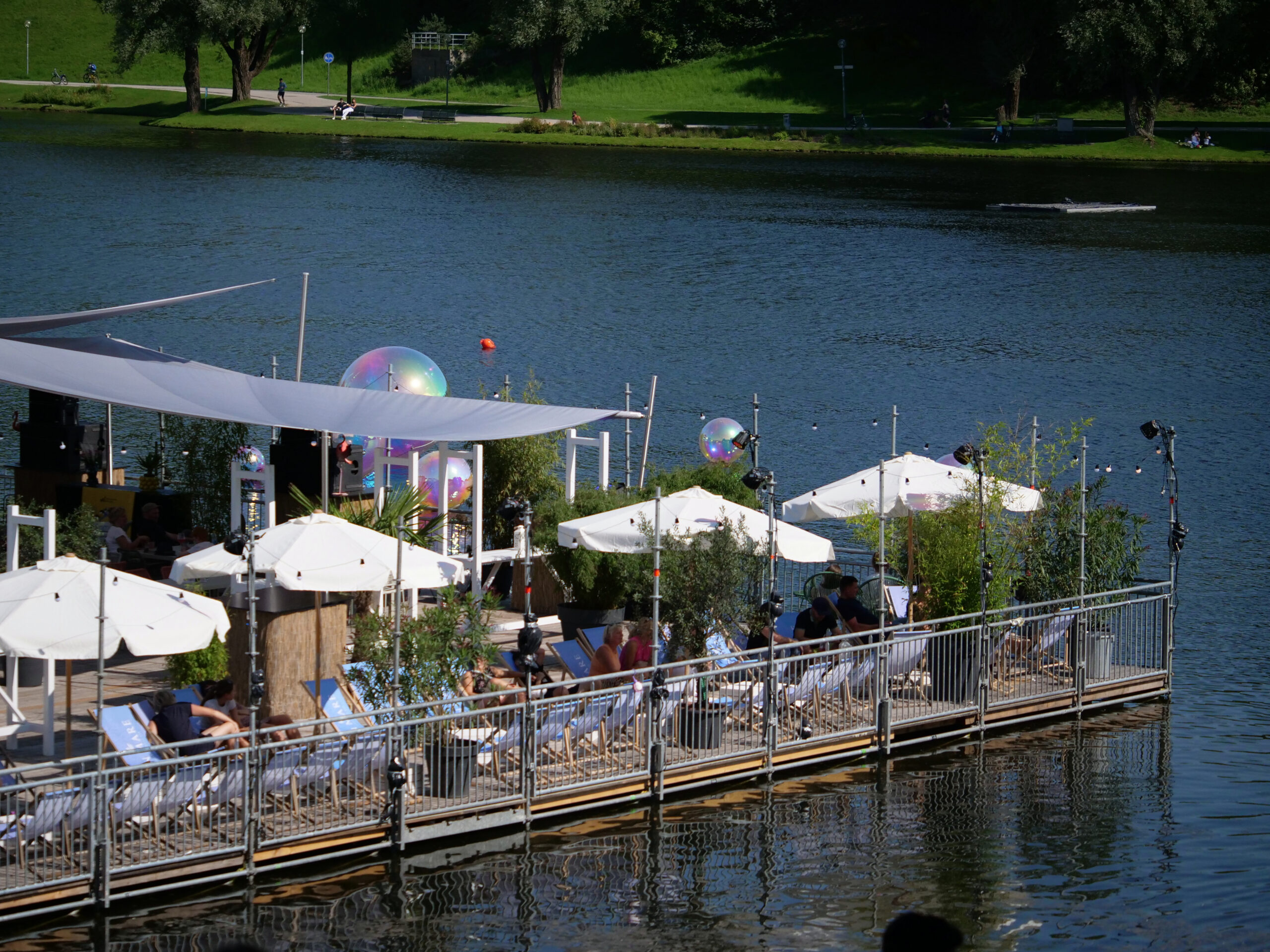 Bar du Soleil Lounge-Bereich mit Sonnenschirmen und Liegestühlen am Olympiasee
