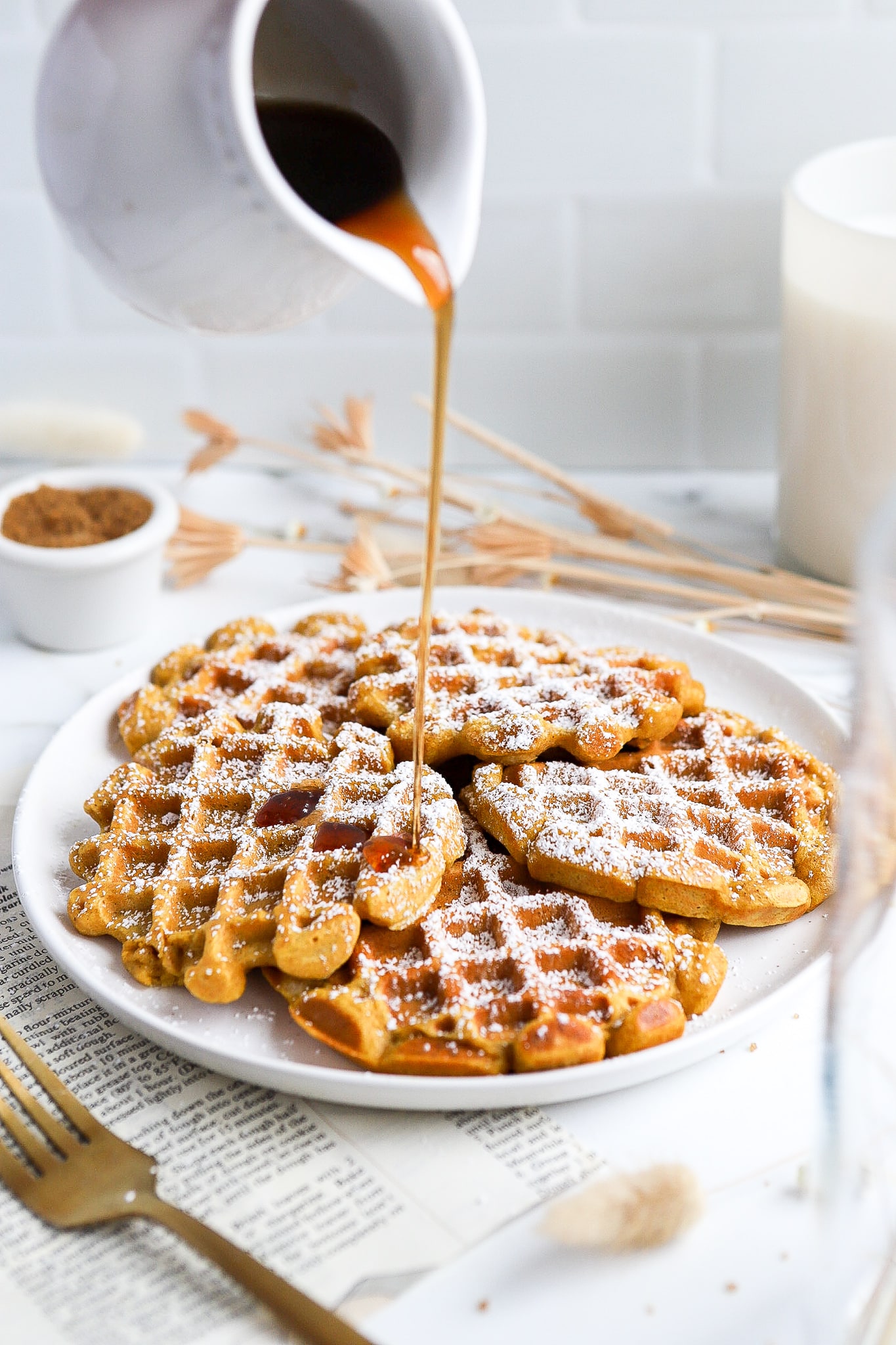 Maple syrup being poured over crispy pumpkin waffles made with pancake mix