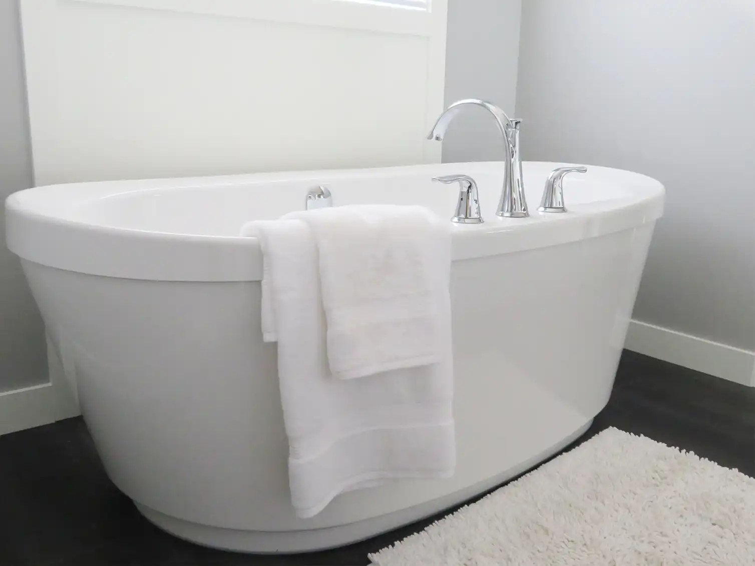 Elegant freestanding bathtub with eco-friendly insulation, surrounded by a cozy bathroom setting for maximum comfort.
