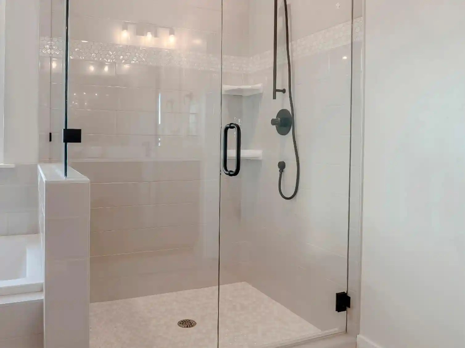 Glass shower doors and enclosures installed during a tub-to-shower conversion for a contemporary, open-concept bathroom design.
