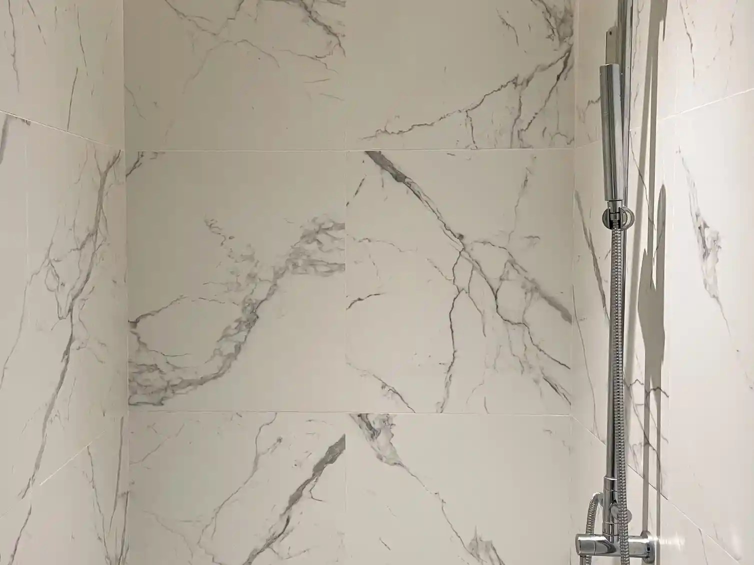Elegant wall panels in a tub-to-shower conversion featuring a sleek marble-textured design for a modern bathroom look.