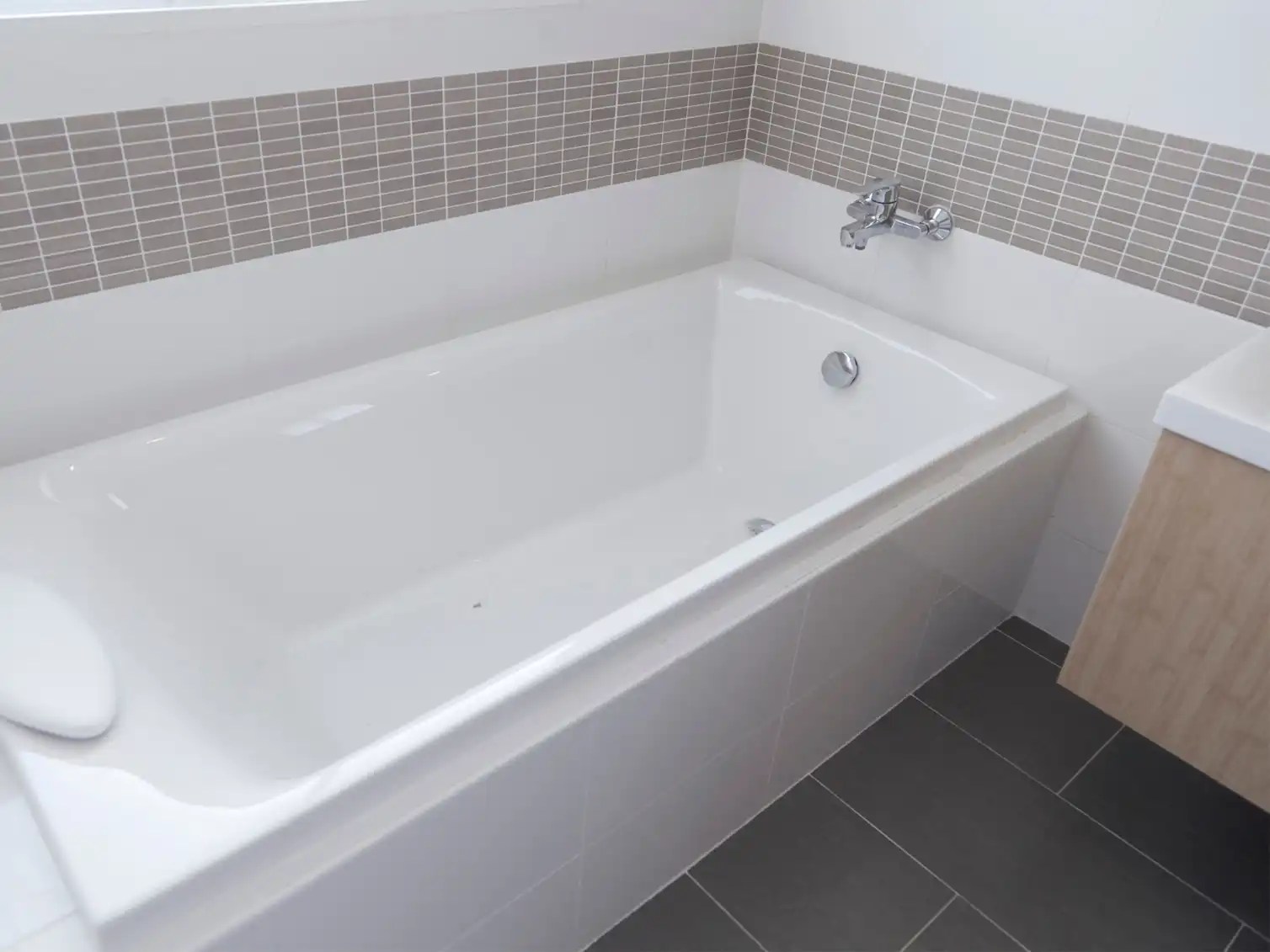 Modern soaking tub with clean, white tiles and sleek design for a stylish and relaxing bathroom upgrade.